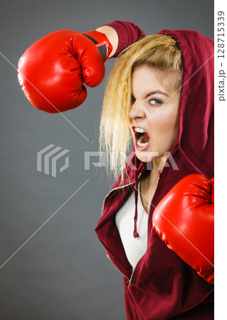 Angry woman wearing boxing gloves 128715339