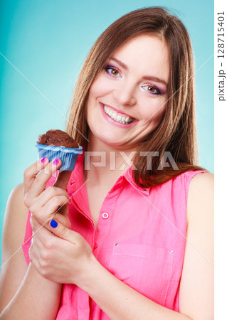 Smiling woman holds chocolate cake in hand 128715401