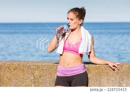 Woman drinking water after sport gym outdoor 128715415