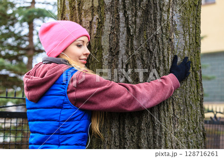 Woman wearing sportswear hugging tree Woman wearing sportswear hugging tree 128716261