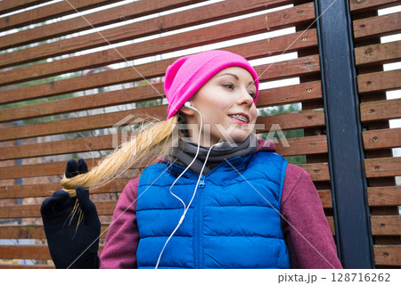 Woman wearing warm sportswear relaxing after exercising Woman wearing warm sportswear relaxing after exercising 128716262