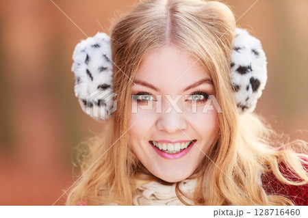 Portrait of pretty smiling woman in fur earmuffs. Portrait of pretty smiling woman in fur earmuffs. 128716460