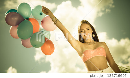Girl holding balloons sky background Girl holding balloons sky background 128716695