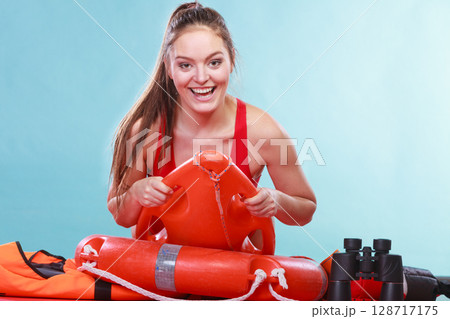Happy lifeguard woman lying on rescue ring buoy. Happy lifeguard woman lying on rescue ring buoy. 128717175