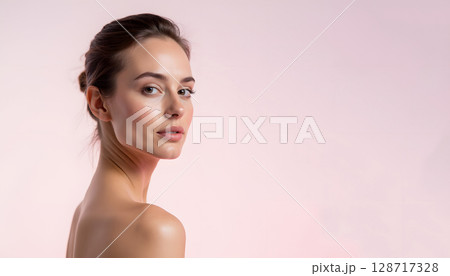 Portrait of a Beautiful Woman with Elegant Hair against a Soft Pink Background 128717328