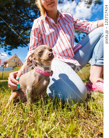 Woman playing pinscher ratter dog outside Woman playing pinscher ratter dog outside 128717434