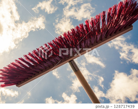 Broom against blue and white cloudy sky 128717439