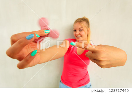 Woman playing fidget spinner 128717440