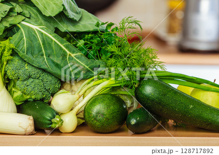 Many green vegetables on kitchen table Many green vegetables on kitchen table 128717892