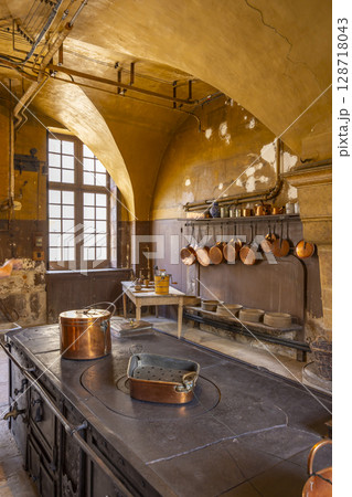 Ancient kitchen showcasing copper pots and pans in Commarin Castle, France 128718043