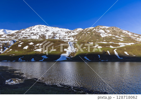 Lago della Rovina reflecting snowy mountains in Piedmont, Italy 128718062