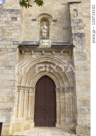 Saint Pierre abbey church entrance showing statue and coat of arms in La Sauve, France Saint Pierre abbey church entrance showing statue and coat of arms in La Sauve, France 128718182