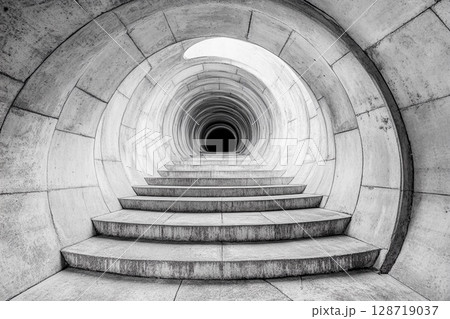 Steps lead into an endless circular tunnel creating a mysterious atmosphere with a sense of depth and intrigue Steps lead into an endless circular tunnel creating a mysterious atmosphere with a sense of depth and intrigue 128719037