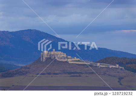 Spis Castle standing tall on a hill at dusk in Slovakia Spis Castle standing tall on a hill at dusk in Slovakia 128719232