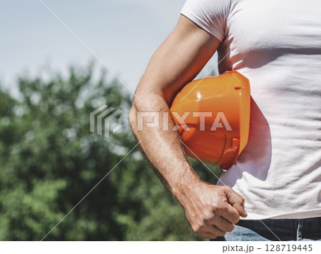 Attractive man, hard hat and work clothes Attractive man, hard hat and work clothes 128719445