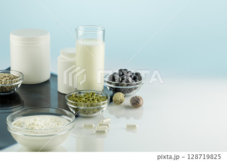 Calcium for health bones and joints. Products rich in calcium, supplements and X-ray film on a doctor desk with copy space. Healthy eating. Food for healthy bones, calcium source 128719825