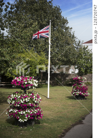 Union flag at centre of village with flower displays 128720747