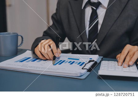 Business financing accounting banking concept. Business woman hand doing finances and calculate on desk about cost at home office. Woman working on desk with using calculator, finance accounting. Business financing accounting banking concept. Business woman hand doing finances and calculate on desk about cost at home office. Woman working on desk with using calculator, finance accounting. 128720751