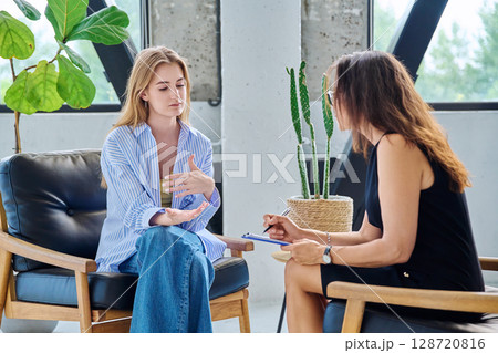 Young woman in psychology session talking with professional therapist, mental specialist. Young woman in psychology session talking with professional therapist, mental specialist. 128720816