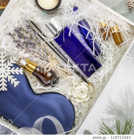 Men winter holidays gift box. Christmas or New Year gift box with sleep care set for men. Preparing self care package with mask for sleep, candle, aroma sticks, cosmetics and fir branches. Flat lay Men winter holidays gift box. Christmas or New Year gift box with sleep care set for men. Preparing self care package with mask for sleep, candle, aroma sticks, cosmetics and fir branches. Flat lay 128721083