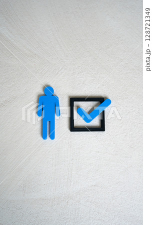 A human figure and a check mark in a checkbox. The concept of compliance with criteria. To mark oneself with one's presence. To be chosen. Meeting job or legal requirements. A human figure and a check mark in a checkbox. The concept of compliance with criteria. To mark oneself with one's presence. To be chosen. Meeting job or legal requirements. 128721349