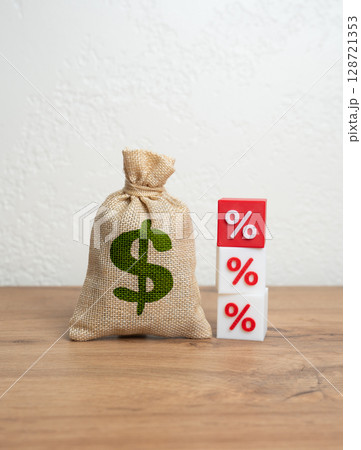 Dollar money bag and red percentage. Rising loan rates or falling investment returns. Financial loss, inflation, or increased tax pressure. Economic risk, fiscal policy tension, or budget imbalance. 128721353