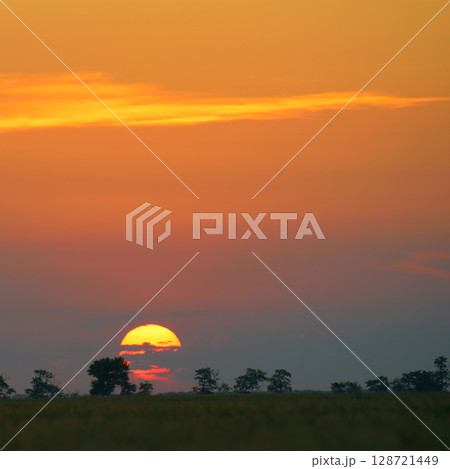 Solar disk and beautiful red sunset over the earth's surface. 128721449