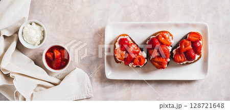 Sandwiches with cream cheese and fried strawberries on a plate on a table top view web banner Sandwiches with cream cheese and fried strawberries on a plate on a table top view web banner 128721648