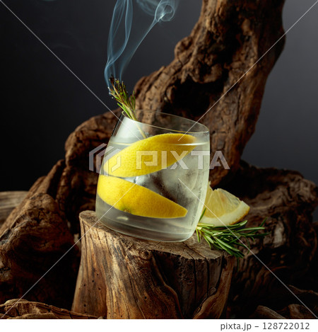 Cocktail gin and tonic with lemon slices and sprig of rosemary. 128722012