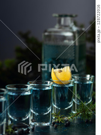 Gin with juniper berries and lemon slices. 128722016