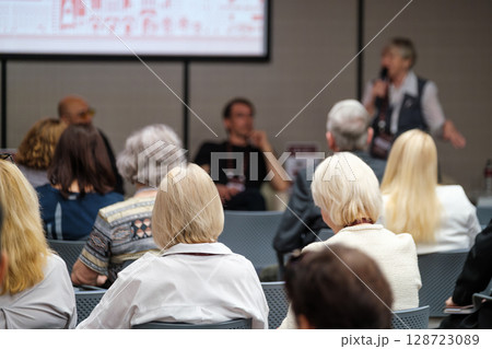 Audience listening to a speaker at a conference or seminar event Audience listening to a speaker at a conference or seminar event 128723089