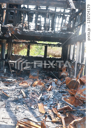 A burned down building with a lot of debris and ash A burned down building with a lot of debris and ash 128724179