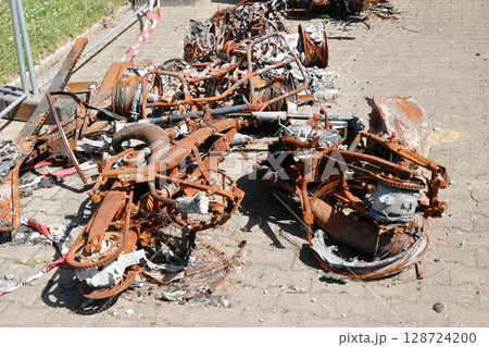 A pile of rusted and burnt metal parts on the ground A pile of rusted and burnt metal parts on the ground 128724200