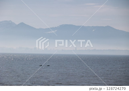 A calm ocean with a mountain range in the background 128724270