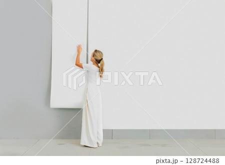 Woman applying blank white wallpaper roll to wall, ai generated 128724488