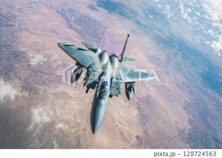 A military fighter jet soars over rugged desert terrain with powerful wings and visible missiles, highlighting airforce strength and aviation dominance A military fighter jet soars over rugged desert terrain with powerful wings and visible missiles, highlighting airforce strength and aviation dominance 128724563