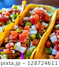 Colorful tacos filled with fresh toppings served on a blue plate at a restaurant 128724611
