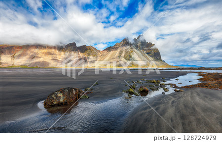 Amazing sunny day and dramatic black sand beach on Stokksnes cape in Iceland 128724979