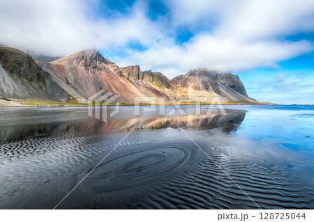Amazing  sunny day and gorgeous reflection of Vestrahorn mountaine on Stokksnes cape in Iceland. 128725044
