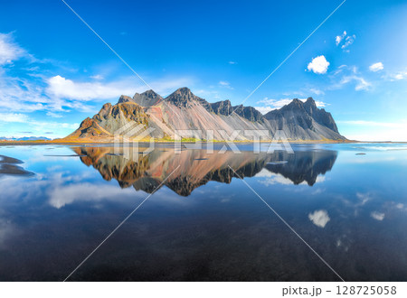 Impressive sunny day and gorgeous reflection of Vestrahorn mountaine on Stokksnes cape in Iceland. Impressive sunny day and gorgeous reflection of Vestrahorn mountaine on Stokksnes cape in Iceland. 128725058