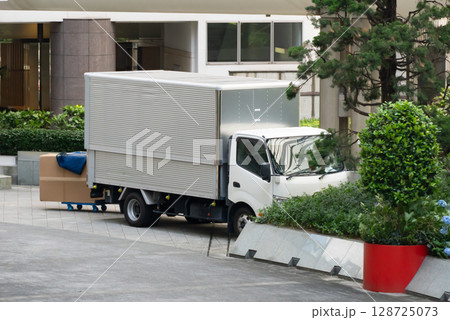 荷物を搬出している配送業者のトラック 128725073