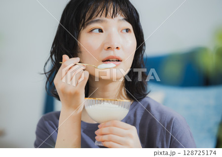 ヨーグルトを食べる若い女性 128725174