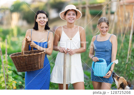 Three women and dog in garden in country house Three women and dog in garden in country house 128725208