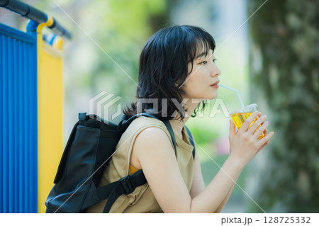 緑の中を歩く女性 128725332