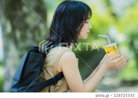 緑の中を歩く女性 128725333