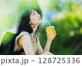緑の中を歩く女性 128725336
