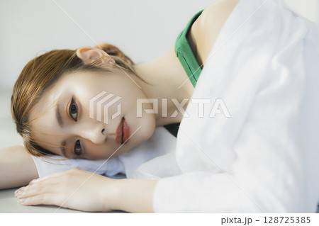 床に寝転ぶ女性 128725385