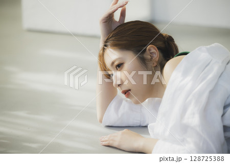 床に寝転ぶ女性 128725388
