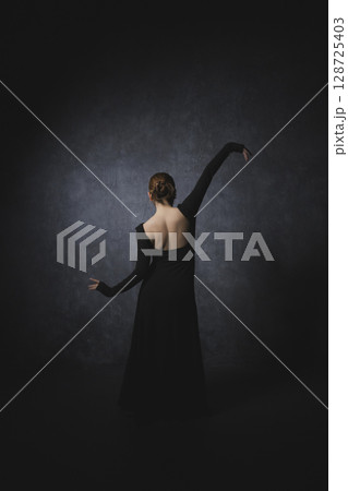 黒背景でポーズをとる女性 黒背景でポーズをとる女性 128725403