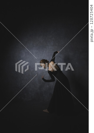 黒背景でポーズをとる女性　　 128725404